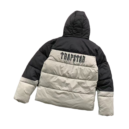 Black and beige puffer jacket with 'TRAPSTAR' branding on a white background